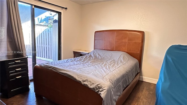 bedroom featuring baseboards and dark wood-type flooring