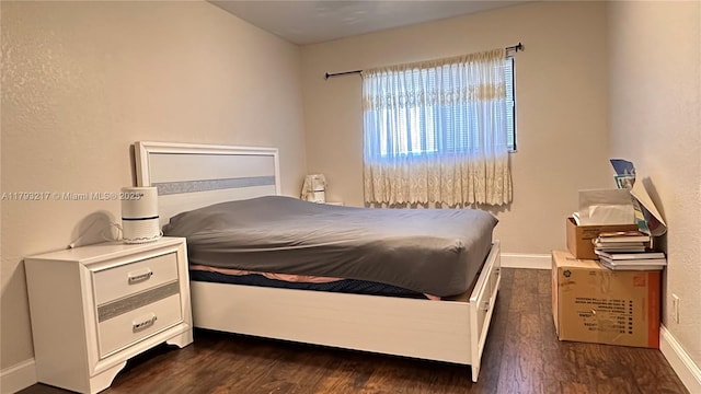 bedroom featuring baseboards and dark wood-type flooring