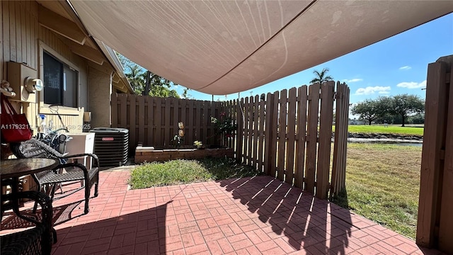 view of patio with central air condition unit and fence
