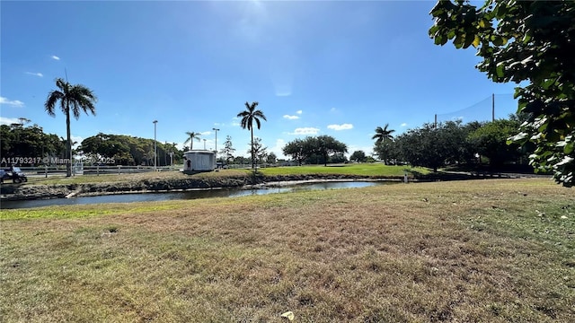 view of yard featuring fence and a water view