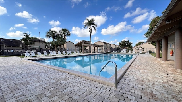 community pool featuring a patio, a gazebo, fence, and a residential view