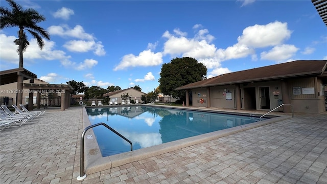community pool with a patio, fence, and a pergola