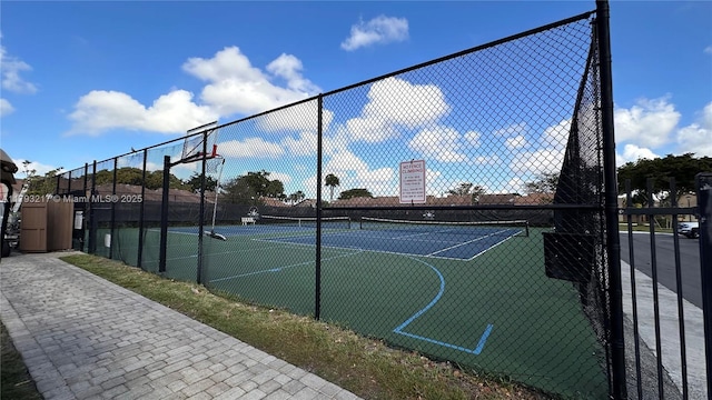 view of basketball court with a tennis court, fence, and community basketball court