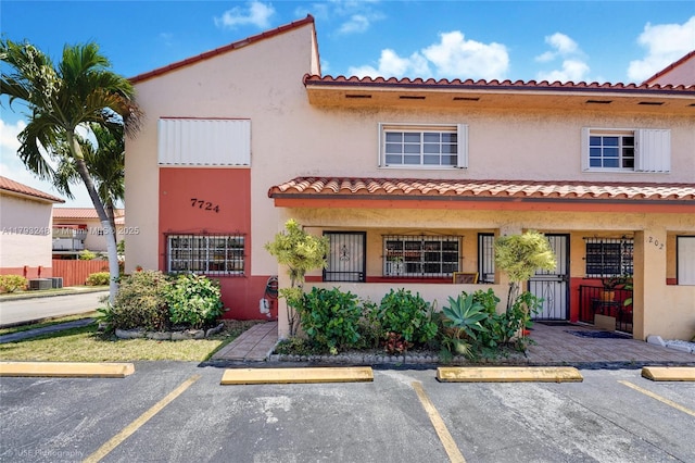 mediterranean / spanish house featuring stucco siding and uncovered parking