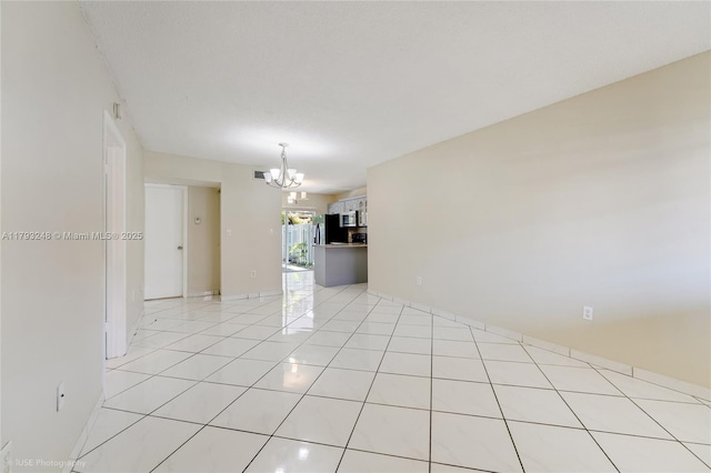 unfurnished room with an inviting chandelier and light tile patterned floors