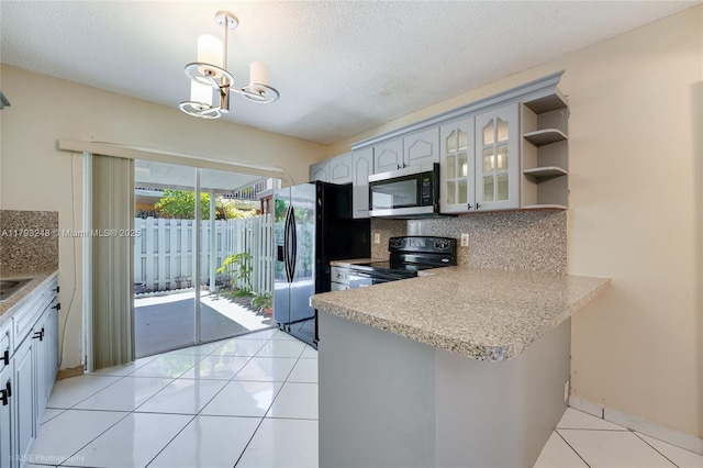 kitchen featuring stainless steel microwave, black electric range oven, fridge with ice dispenser, and tasteful backsplash