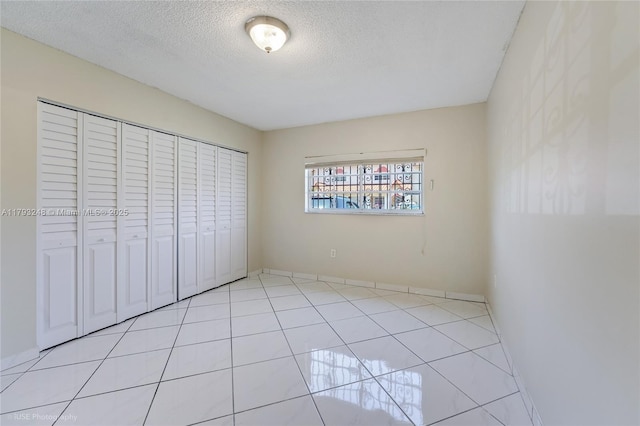 unfurnished bedroom with a textured ceiling and a closet