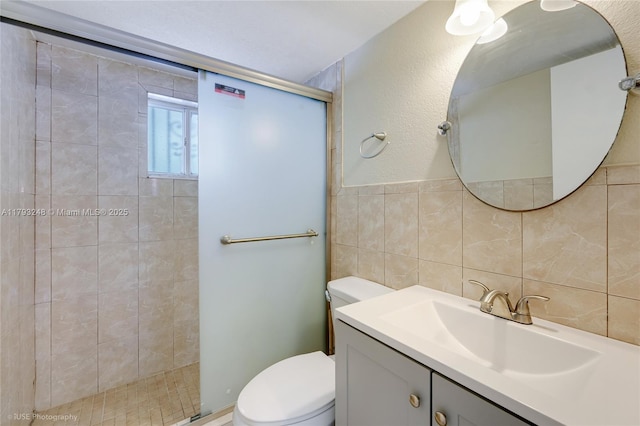 full bath with vanity, toilet, tile walls, and a stall shower
