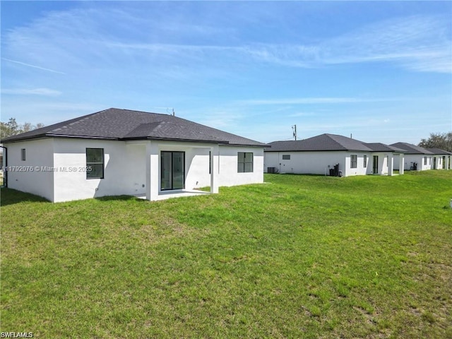 3203 Sunshine Blvd N, Lehigh Acres, FL 33971 - back of house with a shingled roof, stucco siding, and a yard