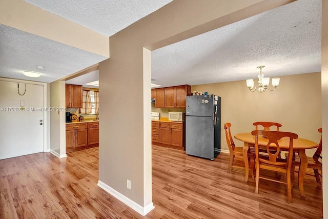 interior space featuring baseboards, light wood-style flooring, and a textured ceiling