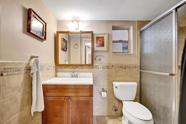 full bath with wainscoting, vanity, toilet, tile walls, and a shower stall