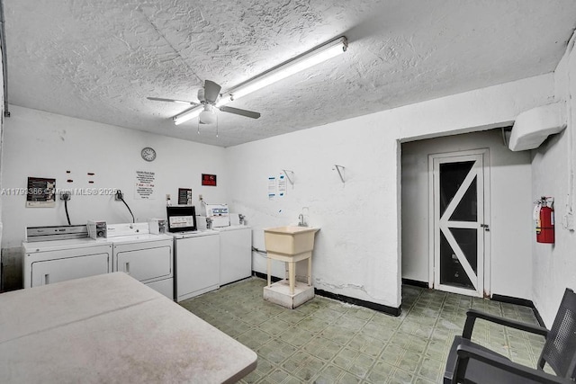 common laundry area featuring washing machine and clothes dryer, a textured ceiling, a ceiling fan, baseboards, and light floors