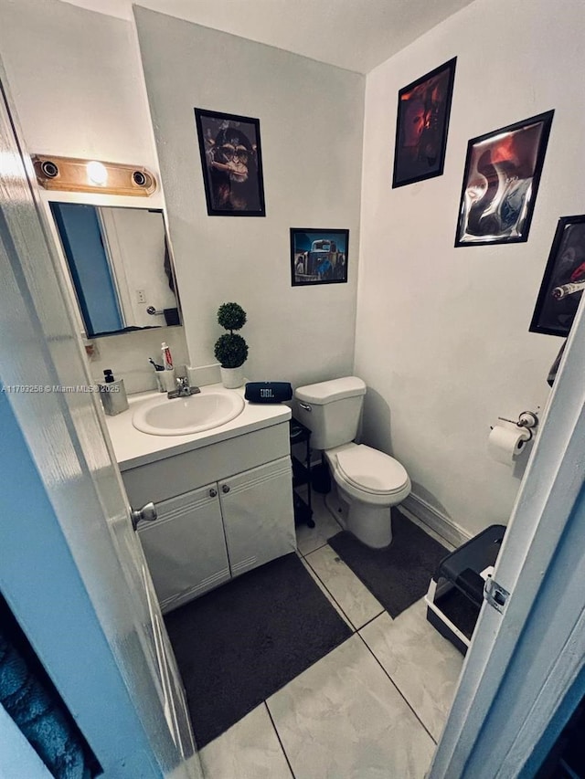 half bathroom featuring vanity and toilet