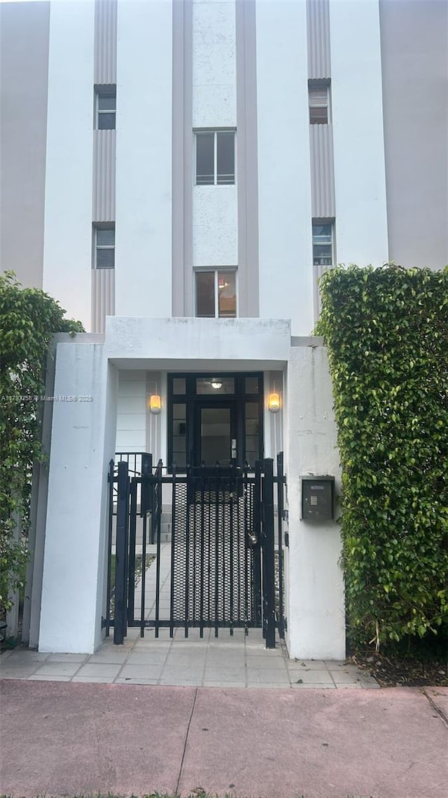 820 Euclid Ave Unit 206, Miami Beach, FL 33139 - view of exterior entry with a gate, stucco siding, and fence