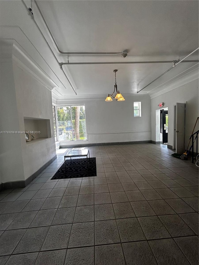 820 Euclid Ave Unit 206, Miami Beach, FL 33139 - unfurnished living room featuring ornamental molding, dark tile patterned flooring, and baseboards