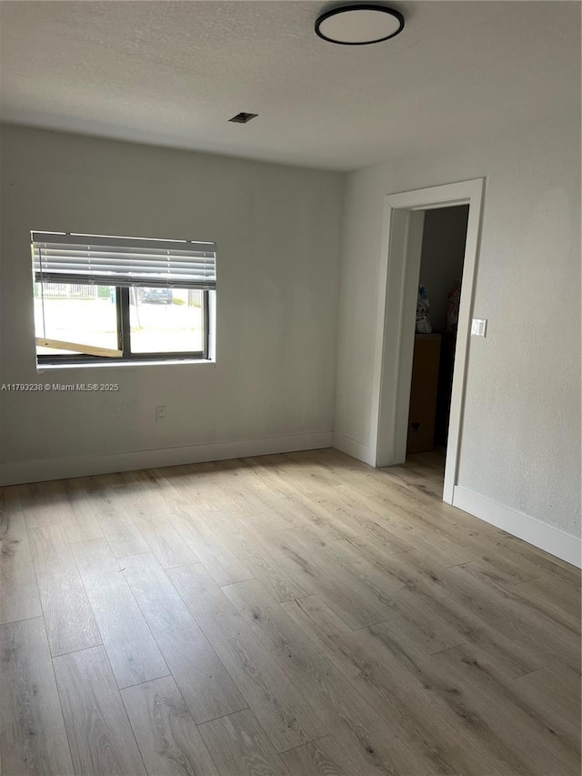 unfurnished room with baseboards and wood finished floors