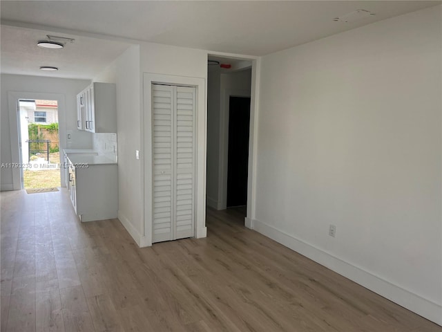 empty room featuring baseboards and light wood-style flooring