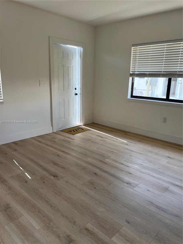 empty room with baseboards and wood finished floors