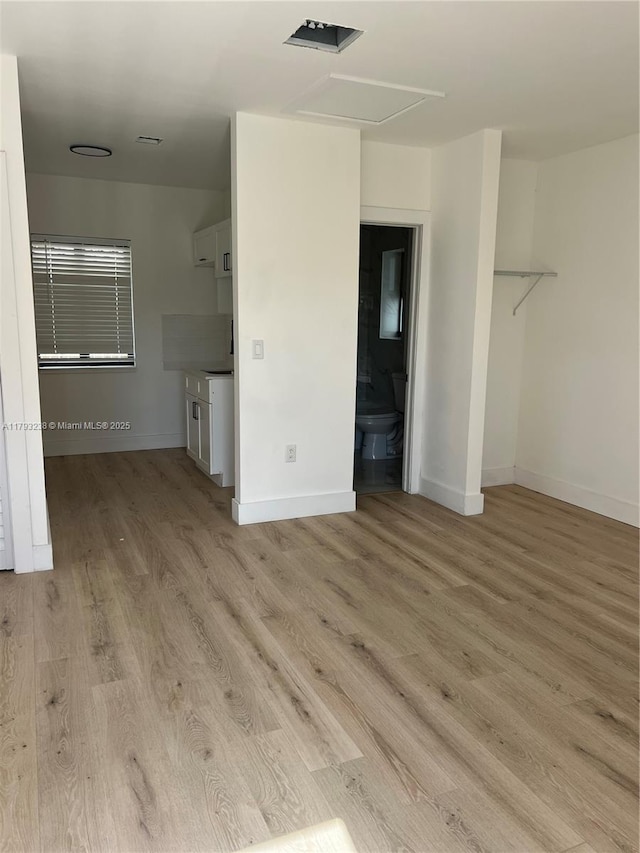 unfurnished bedroom with baseboards and light wood-style floors