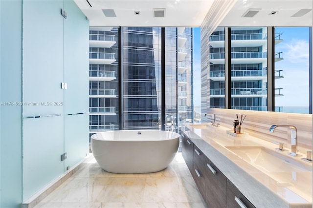 17141 Collins Ave Unit 3002, Sunny Isles Beach, FL 33160 - bathroom featuring double vanity, a wall of windows, a sink, and a freestanding bath