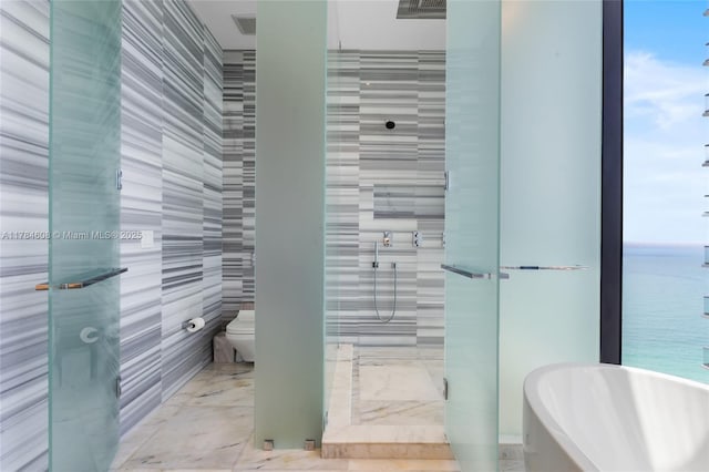 17141 Collins Ave Unit 3002, Sunny Isles Beach, FL 33160 - bathroom with marble finish floor, toilet, tile walls, tiled shower, and a water view