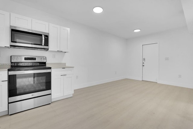 1814 NW 2nd Ct, Miami, FL 33136 - kitchen with appliances with stainless steel finishes, light wood-style floors, white cabinets, light countertops, and recessed lighting