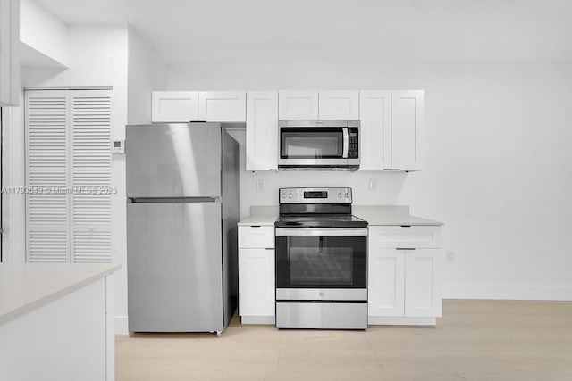1814 NW 2nd Ct, Miami, FL 33136 - kitchen featuring appliances with stainless steel finishes, light wood-type flooring, and white cabinets