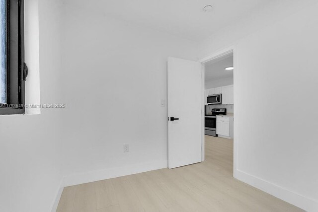 1814 NW 2nd Ct, Miami, FL 33136 - kitchen featuring white cabinetry, light wood-type flooring, and a sink
