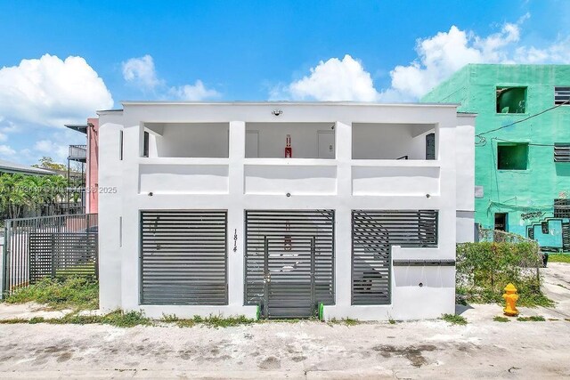 1814 NW 2nd Ct, Miami, FL 33136 - rear view of property featuring stucco siding, fence, and a balcony