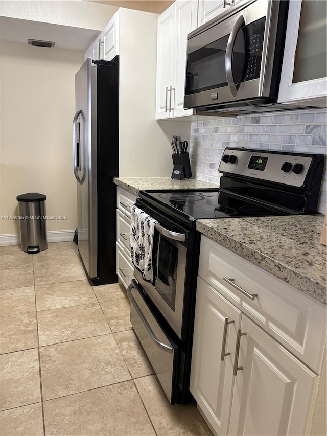 kitchen with stainless steel appliances, tasteful backsplash, light stone counters, visible vents, and white cabinets