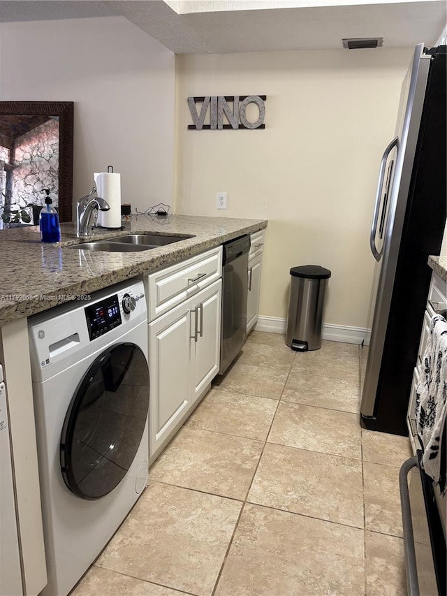 clothes washing area featuring a sink, washer / dryer, laundry area, light tile patterned flooring, and visible vents