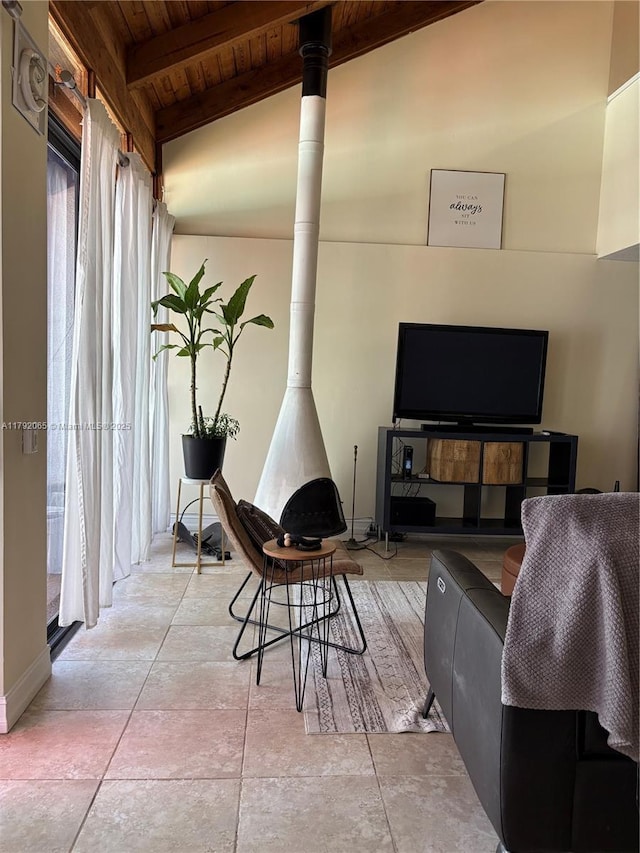 living area with a wood stove, wood ceiling, lofted ceiling with beams, and a healthy amount of sunlight