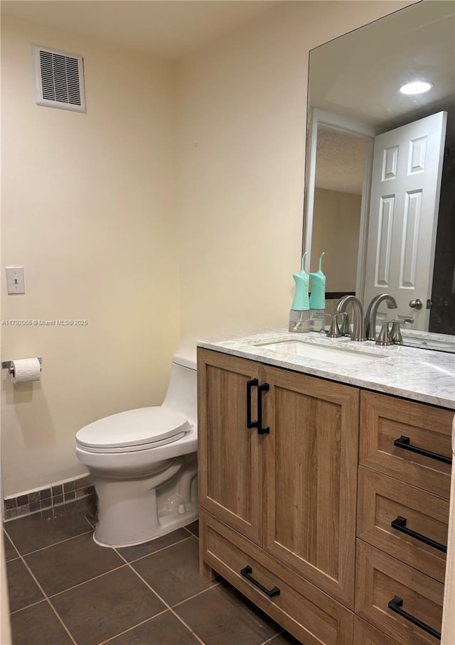 half bathroom with tile patterned floors, toilet, visible vents, and vanity