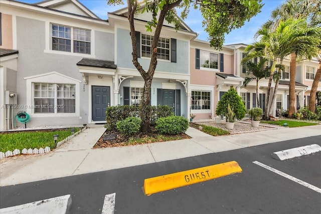 multi unit property featuring stucco siding and uncovered parking