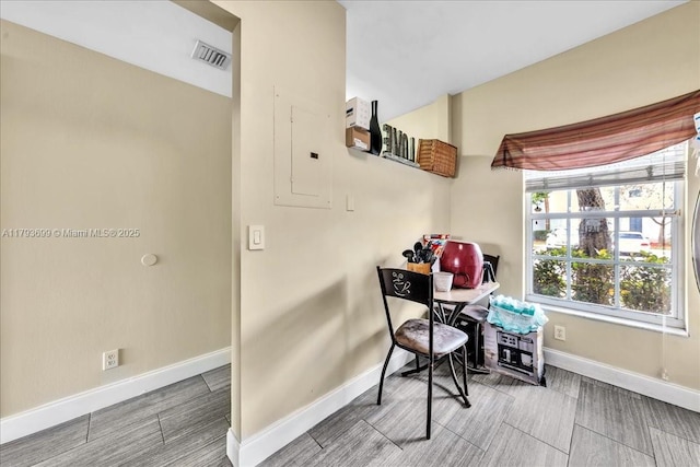 office space featuring baseboards, visible vents, electric panel, and wood tiled floor