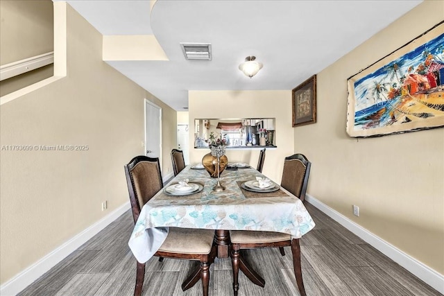 dining area with baseboards, wood finished floors, and visible vents