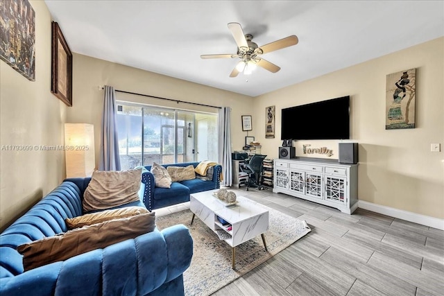 living room with baseboards, ceiling fan, and wood tiled floor