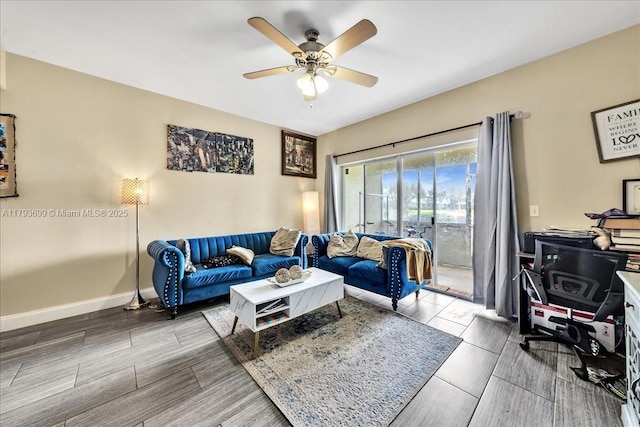 living room featuring a ceiling fan, baseboards, and wood finished floors