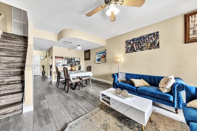 living area with baseboards, ceiling fan, wood finished floors, and visible vents