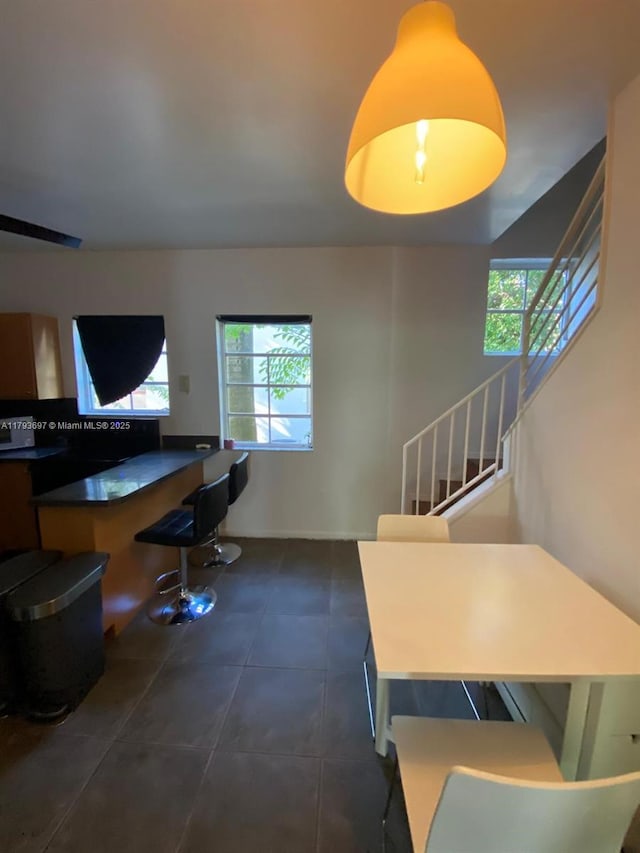 1525 Pennsylvania Ave Unit 5, Miami Beach, FL 33139 - living area featuring a healthy amount of sunlight, dark tile patterned flooring, and stairs