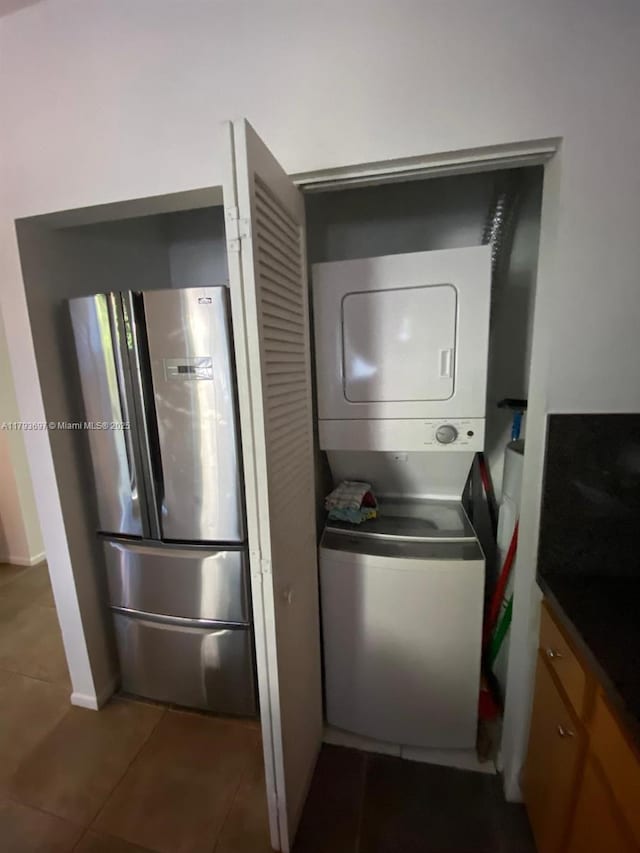 1525 Pennsylvania Ave Unit 5, Miami Beach, FL 33139 - laundry area with dark tile patterned flooring, stacked washer / drying machine, baseboards, and laundry area