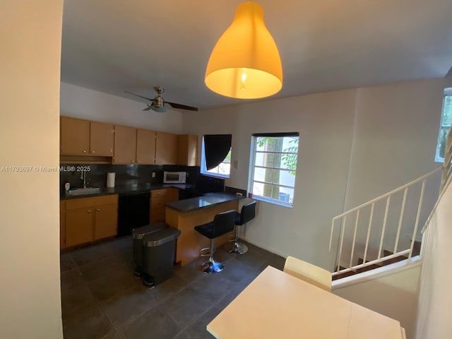 1525 Pennsylvania Ave Unit 5, Miami Beach, FL 33139 - kitchen featuring a ceiling fan, tasteful backsplash, dishwasher, white microwave, and a peninsula