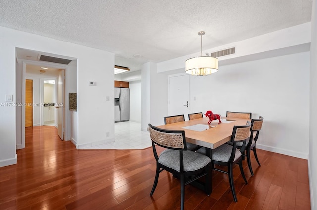 19101 NE 36th Ct Unit 2509, Aventura, FL 33180 - dining area featuring a textured ceiling, visible vents, and hardwood / wood-style flooring
