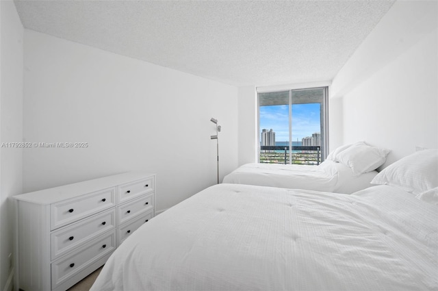 19101 NE 36th Ct Unit 2509, Aventura, FL 33180 - bedroom featuring a water view, a textured ceiling, and access to exterior