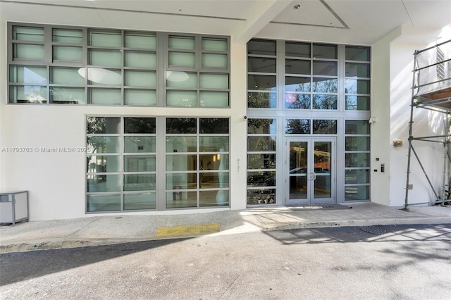 view of exterior entry featuring french doors and stucco siding