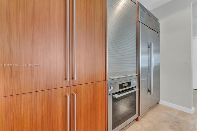 kitchen with appliances with stainless steel finishes, light tile patterned floors, and modern cabinets