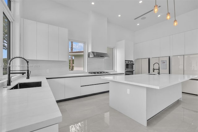 7900 SW 70th St, Miami, FL 33143 - kitchen featuring modern cabinets, a high ceiling, white cabinetry, light countertops, and decorative light fixtures