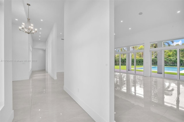 7900 SW 70th St, Miami, FL 33143 - corridor featuring healthy amount of natural light, a towering ceiling, a chandelier, tile patterned floors, and recessed lighting