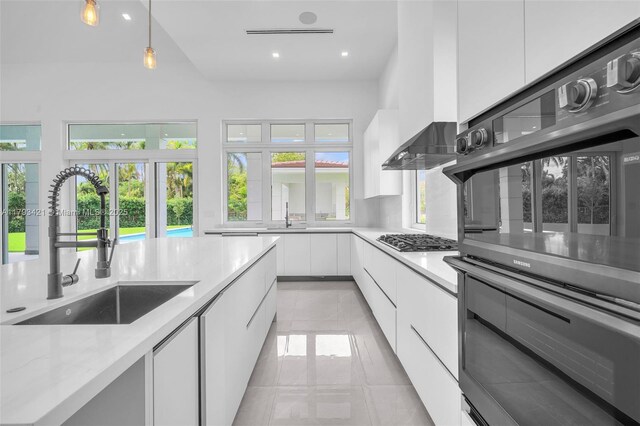 7900 SW 70th St, Miami, FL 33143 - kitchen with modern cabinets, healthy amount of natural light, white cabinets, stainless steel gas cooktop, and recessed lighting