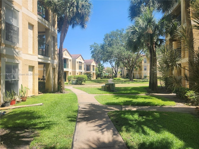 view of property's community featuring a lawn and a residential view